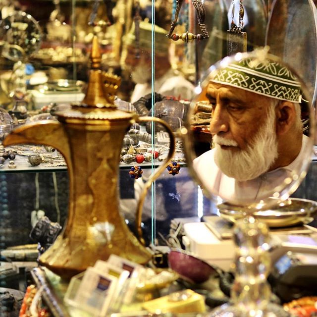 A shopkeeper selling antique copper coffee pots at the Mattrah souq. #oman #muscat #market #dallah